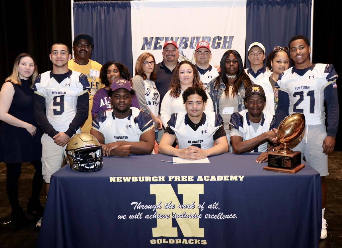 Eight students who signed to play football in college with their family.