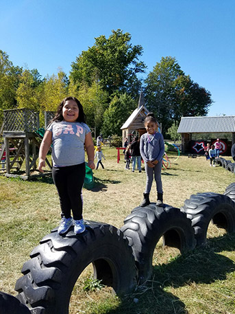 Other students playing on farm playground.
