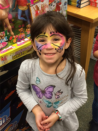 A student has her face painted at the event