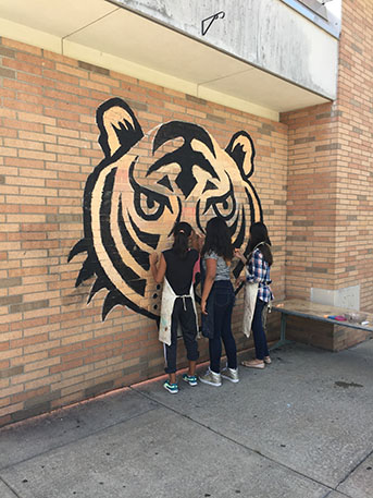 Another photo of students working on mural