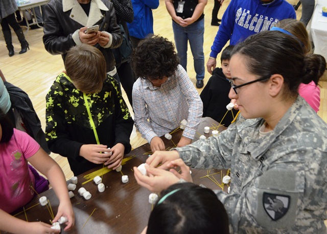 A Cadet works with students on projects
