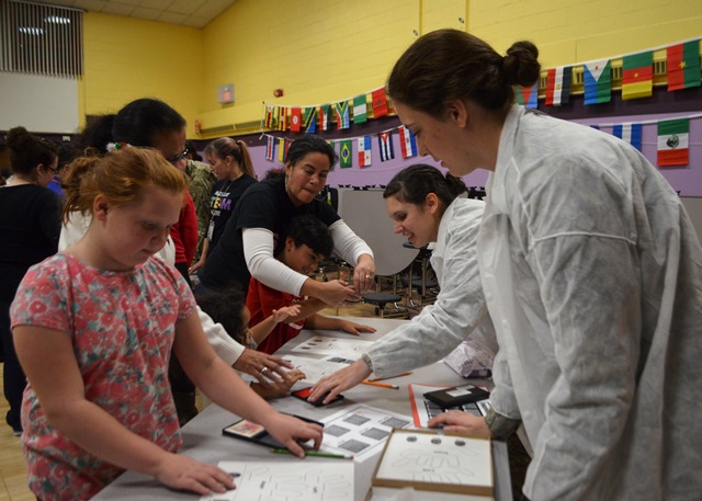 Students work with cadets on a project