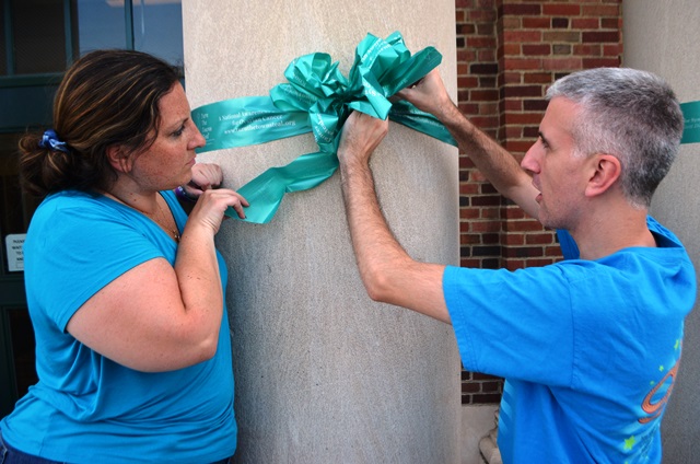 Two teachers working together to tie a ribbon