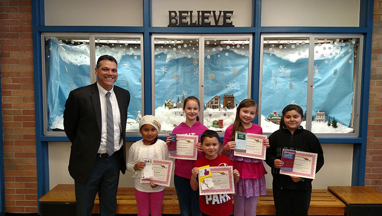 Winners of the Temple Hill Academy December essay contest, Traditions, pose with their principal, Mr. Lopez.